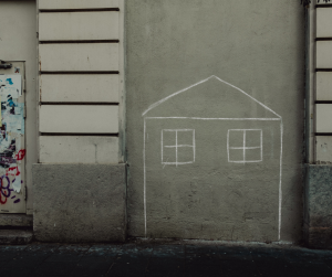 A child like chalk drawing of a house on an exterior wall.