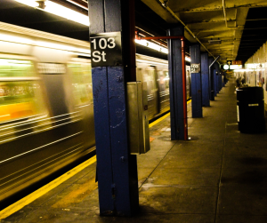 A stylised image of a New York subway train moving at speed past 103rd Street station. 