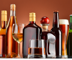 A line-up of variosu alcoholic drinks in bottles, including whiskey, brandy, beer, and wine. 