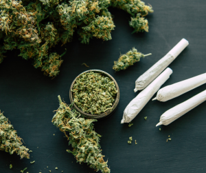 Buds of cannabis, skunk, next to four joints. 
