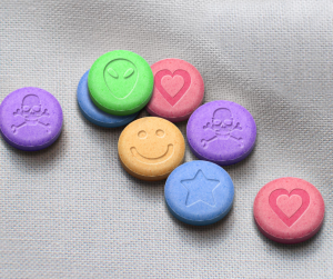 A close up of colourful MDMA / Ecstaasy tablets in different colours
