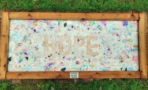 The Hope Mosaic at Dutch Farm - a collection of broken plate fragments spelling out the word "Hope".