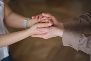 A close up of ladies holding hands in a gesture of support. 